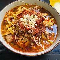 7:Pour the broth and pork over the bean sprouts, then add garlic and chili powder