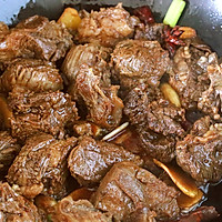 4:Return beef, add spices and hot water, then simmer covered